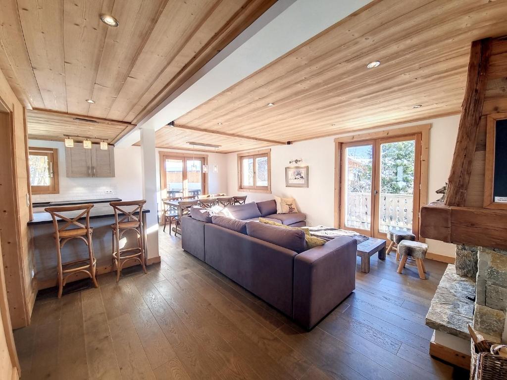 Il comprend un grand salon avec un canapé et une cuisine. dans l'établissement Chalet Framboisiere - 10 pers - proche piste, aux Gets