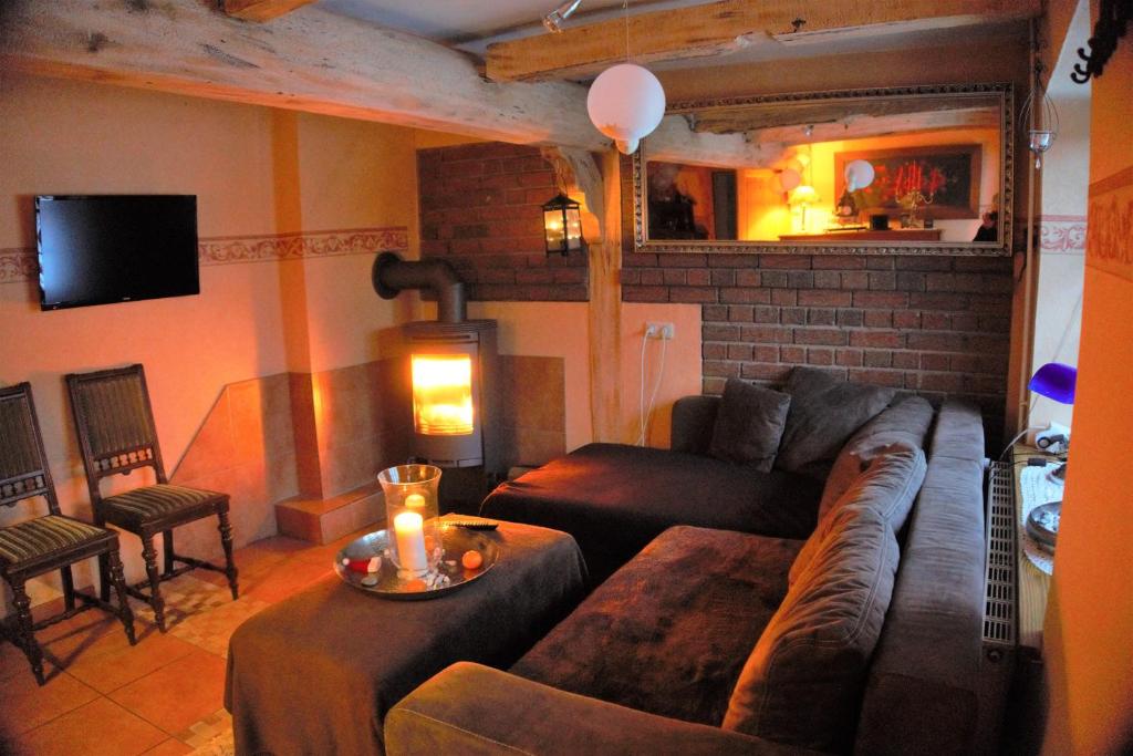 a living room with a couch and a table at Altes Landhaus Oste, Klavier Appartement, 2 Zimmer mit Kamin in Hemmoor