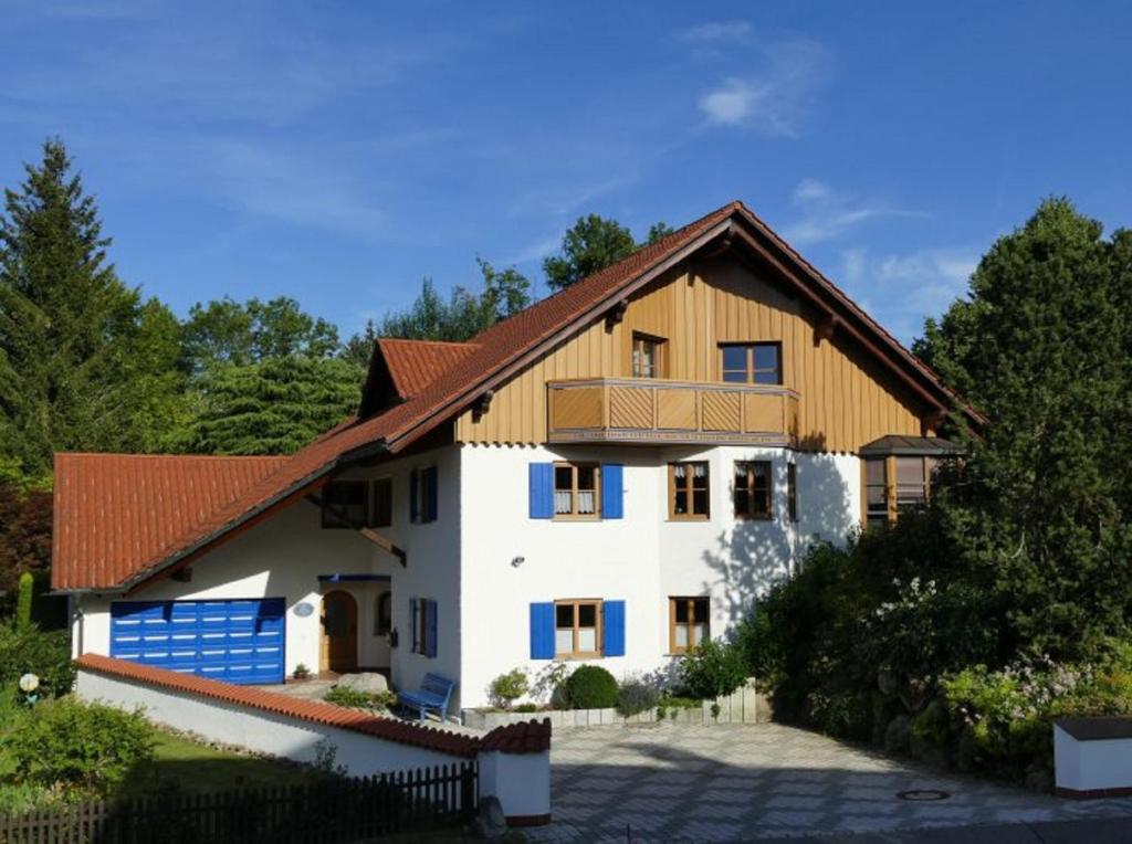 a large white house with a wooden roof at Ferienwohnung am Kneipp-Park in Scheidegg
