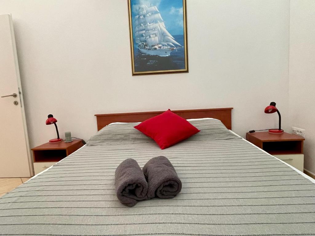a bedroom with a bed with a red pillow and towels at Spacious Apartment in Vabriga