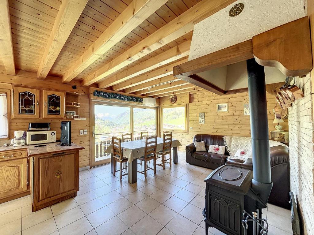 a kitchen and living room with a stove in a cabin at Chalet Les Hotelieres - 8 pers - Proche des pistes in Les Gets