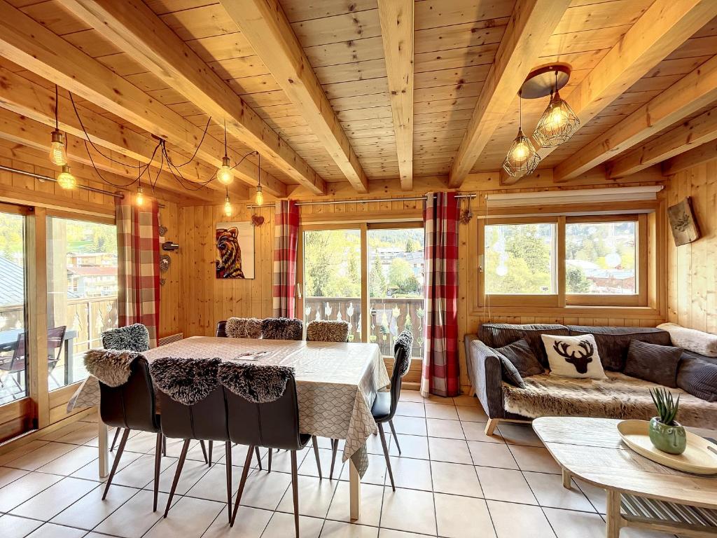 un salon avec une table et un canapé dans l'établissement Chalet Olympiades -8 pers - proche centre, aux Gets