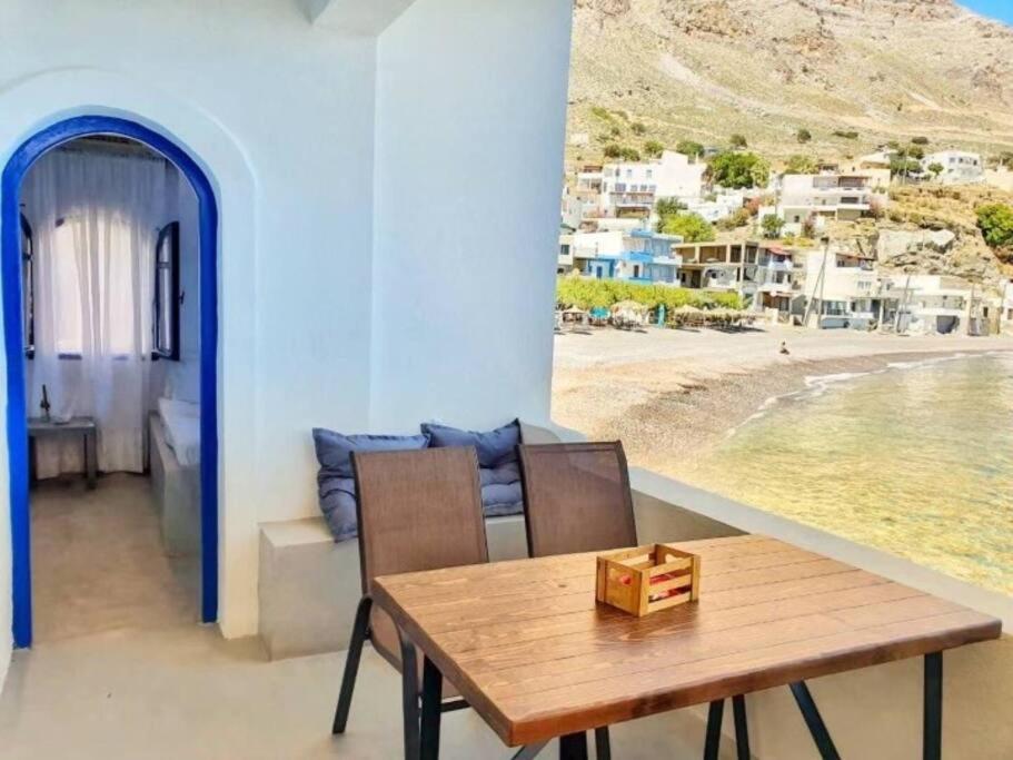 ein Esszimmer mit einem Tisch und Strandblick in der Unterkunft Galini in Paránimfoi