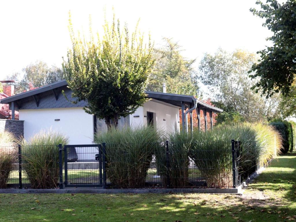 una cerca frente a una casa con hierba alta en Holiday home Luebben, en Lübben