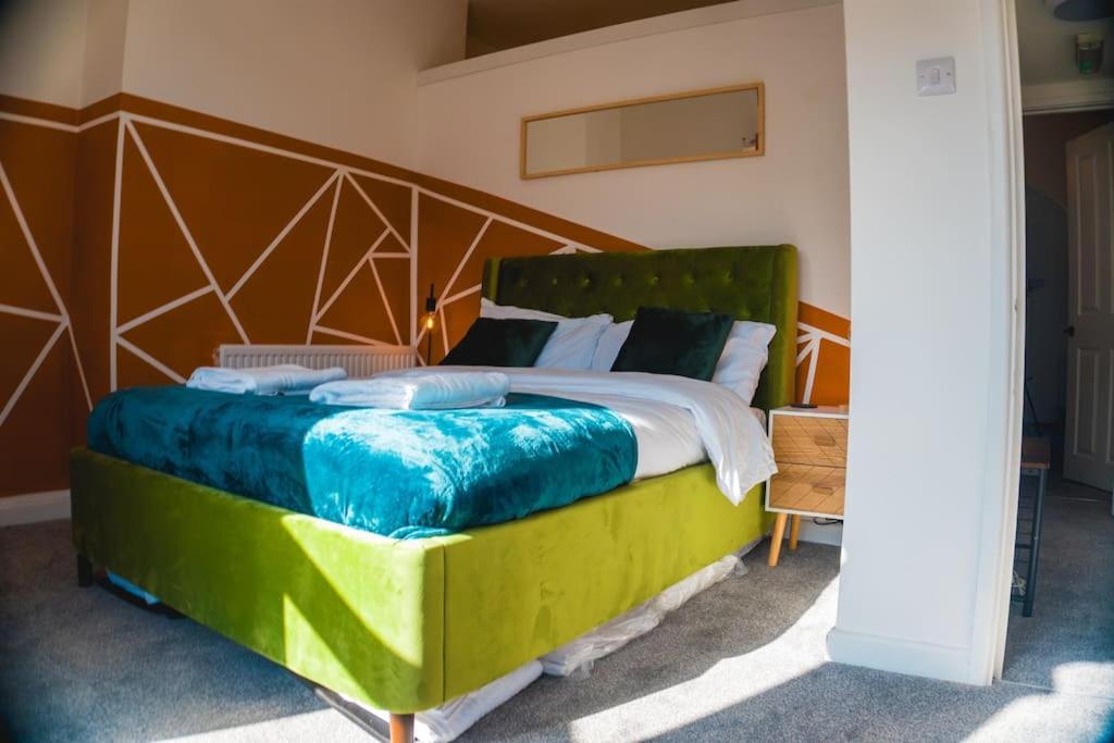 a bedroom with a large bed with a wooden headboard at Perfect Stays in Mutely for Couples in Plymouth