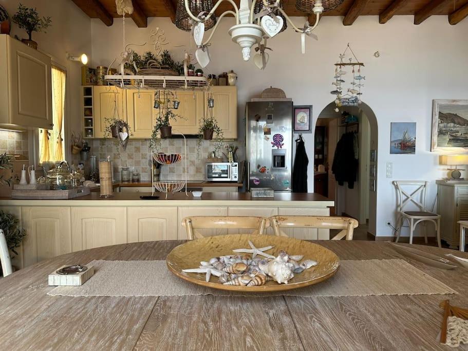 a kitchen with a table with a bowl of shells on it at Beachfront House Kipri in Kipri