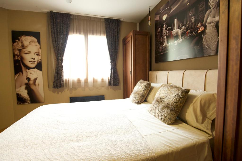a bedroom with a white bed with pictures on the wall at Luxury Apartments Croatia in Banjole