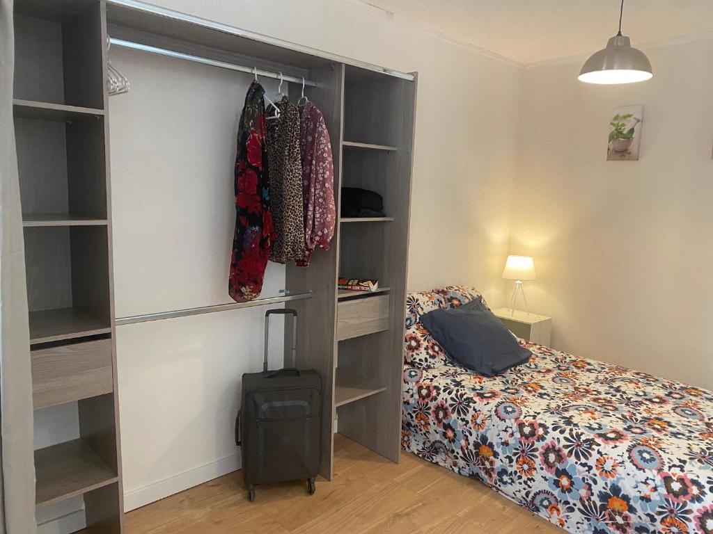 ein Schlafzimmer mit einem Bett und einem Schrank in der Unterkunft Studio en plein centre des Vans in Les Vans