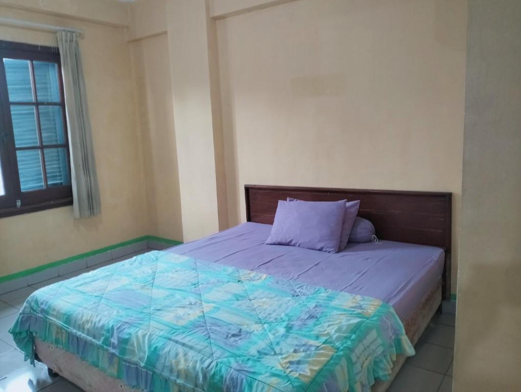 a bedroom with a bed with a purple comforter and a window at Hotel Lippo Carita bay Wanda01 in Carita