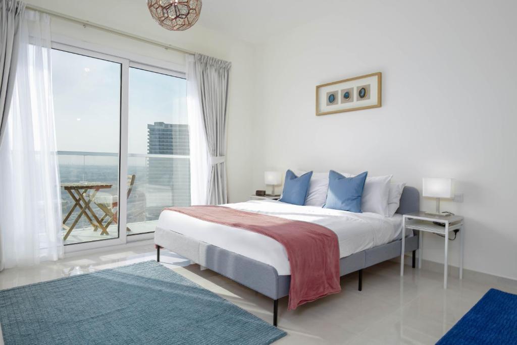 a bedroom with a large bed and a large window at Lux BnB I AG Tower I Canal Views in Dubai