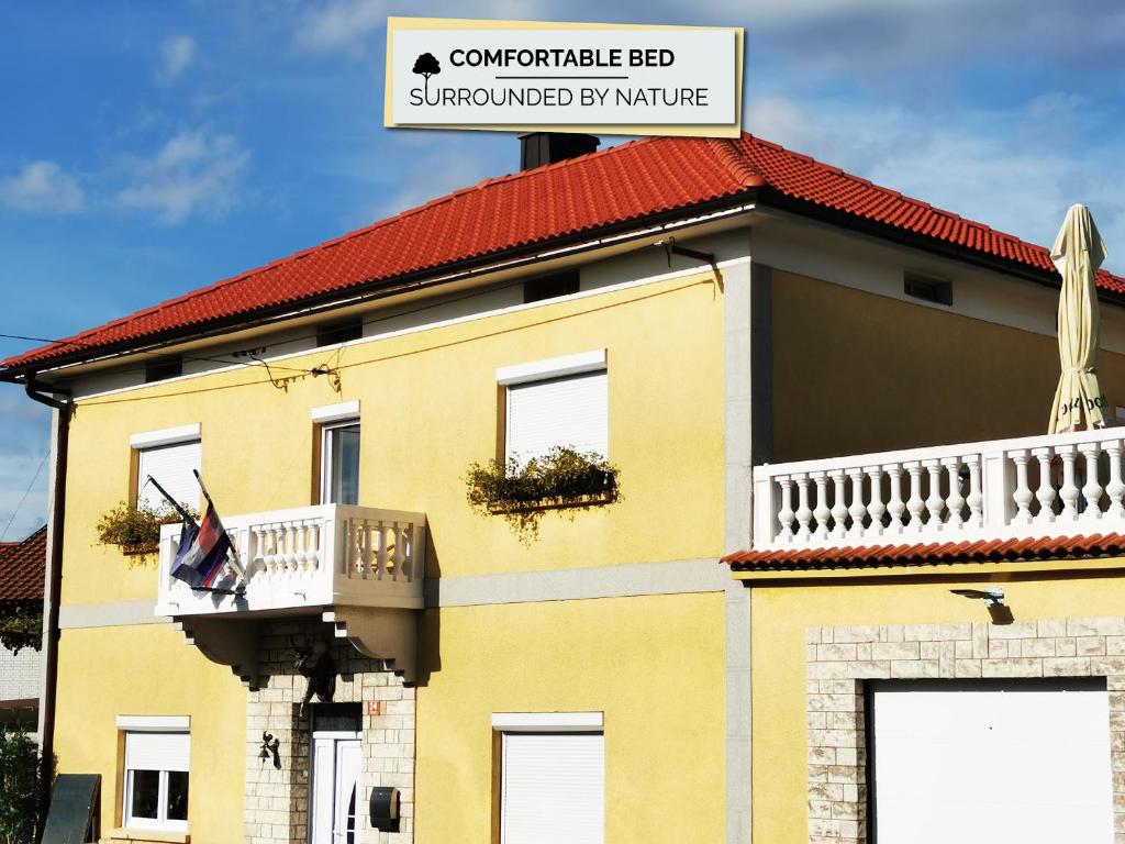 un edificio amarillo con balcón y una señal en él en Vila Antik, en Ilirska Bistrica