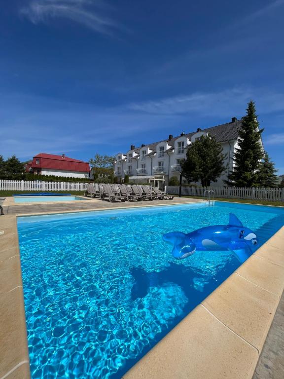 a swimming pool with two dolphins in the water at Pensjonat Zenit in Ustronie Morskie