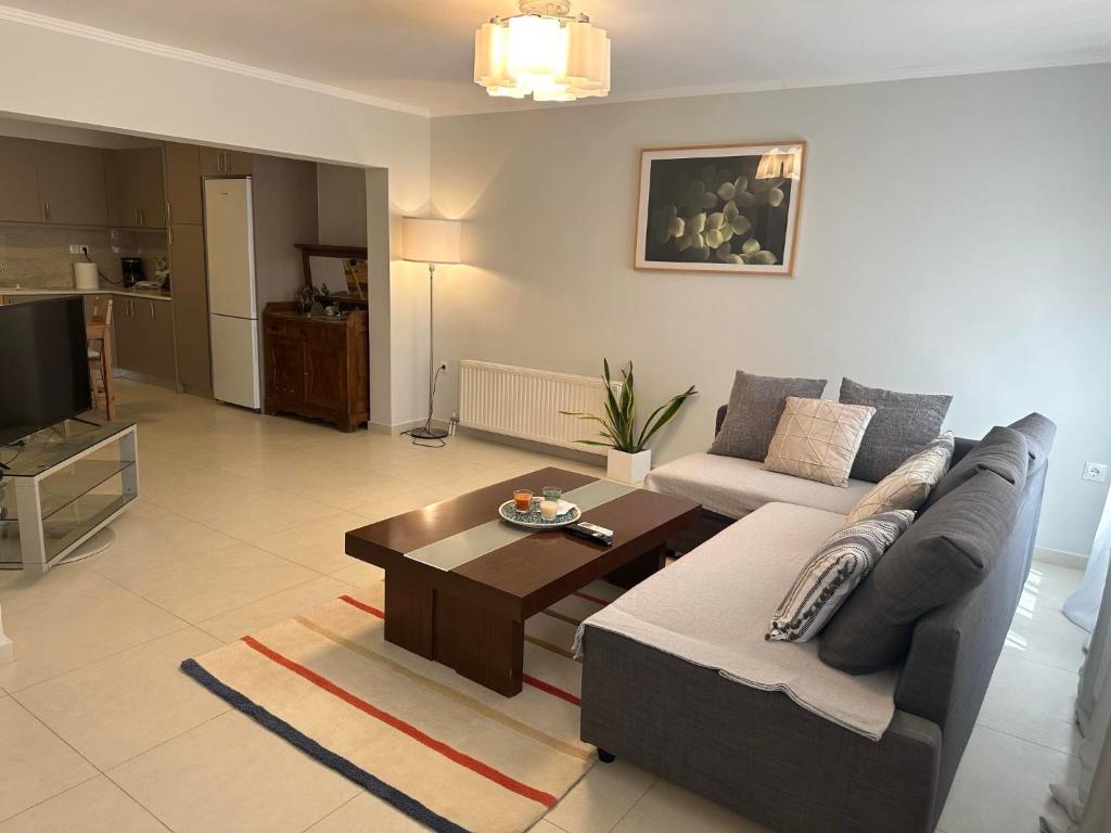 uma sala de estar com um sofá e uma mesa de centro em Deppys Apartment Porto Heli em Porto Heli