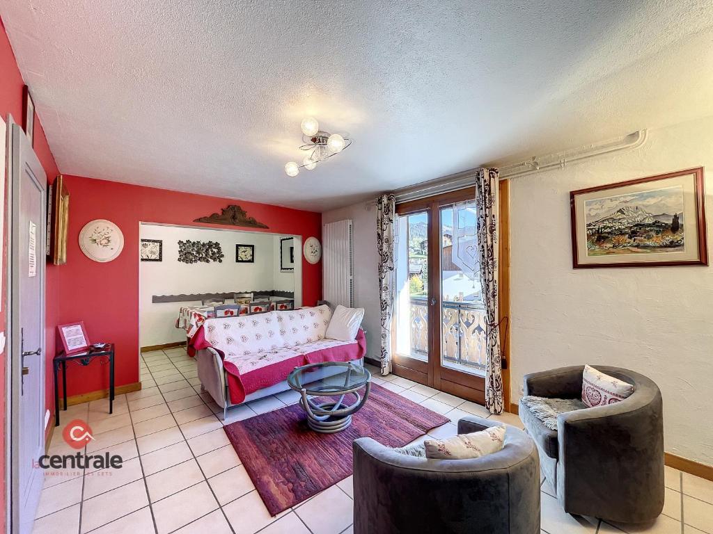 - un salon avec des murs rouges, un canapé et des chaises dans l'établissement Clos 11 - appartement - 8 pers - proche centre, aux Gets