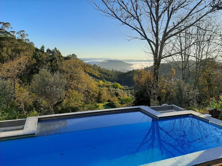 a blue swimming pool with a view of the mountains at Casa Estrela in Alvaiázere