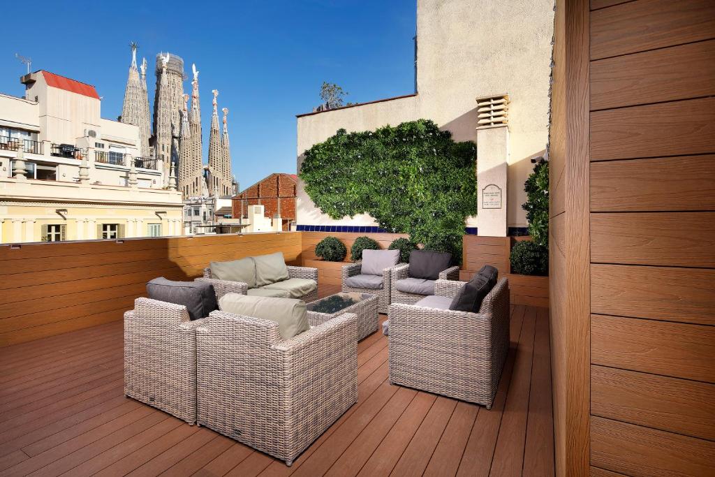 a balcony with wicker chairs and couches on a building at Apartaments-Hotel Hispanos 7 Suiza in Barcelona