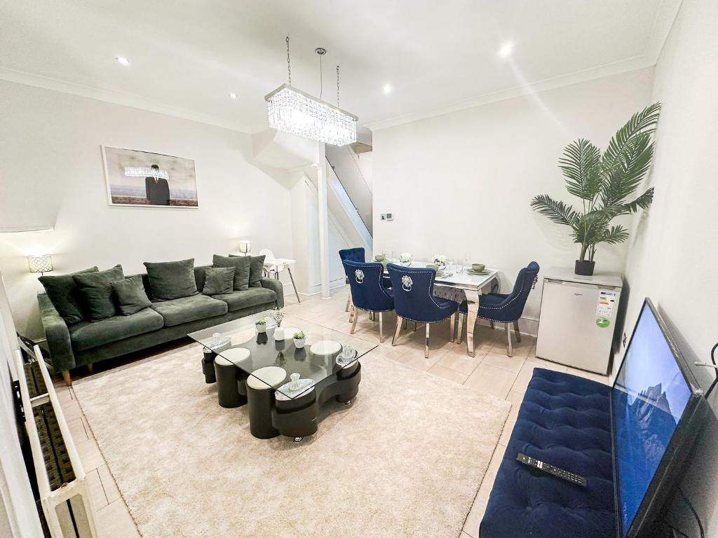 a living room with a couch and a table at Enchanting 3Bed, 2 Reception Apartment w/ Private Garden & Parking in Ilford in Barking