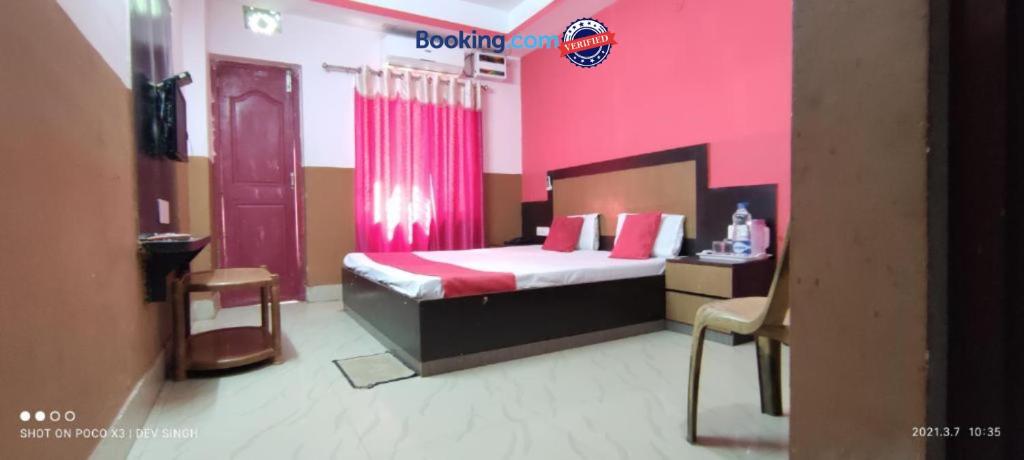 a bedroom with a bed and a pink wall at Hotel Samrat Palace Puri Near Sea Beach Excellent Service in Puri