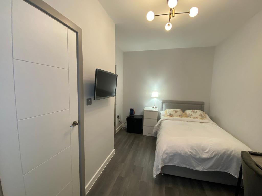 a bedroom with a bed and a flat screen tv at nana house in London