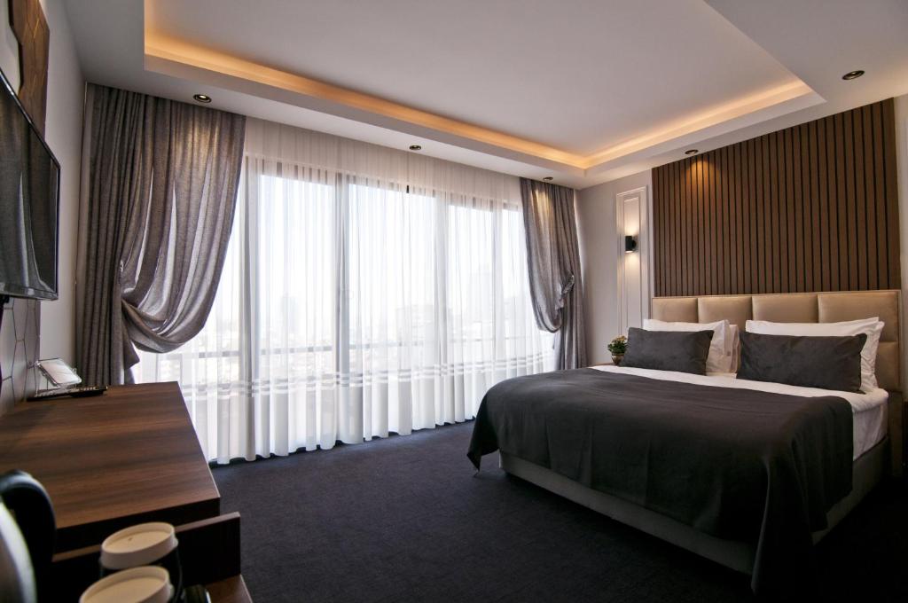 una camera d'albergo con un letto e una grande finestra di VALİDE RESİDENCE a Istanbul