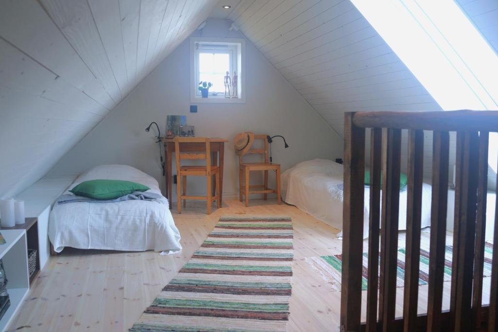 Schlafzimmer im Dachgeschoss mit einem Bett und einem Schreibtisch mit einem Tisch in der Unterkunft Loft Apartment at Isola Gård on the middle of Öland in Färjestaden