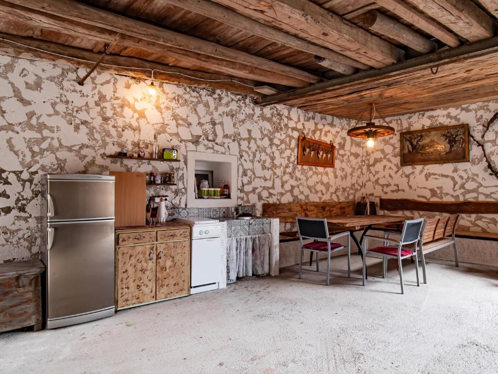 La cuisine est équipée d'une table, de chaises et d'un réfrigérateur. dans l'établissement Šišnikova hiša, à Ilirska Bistrica