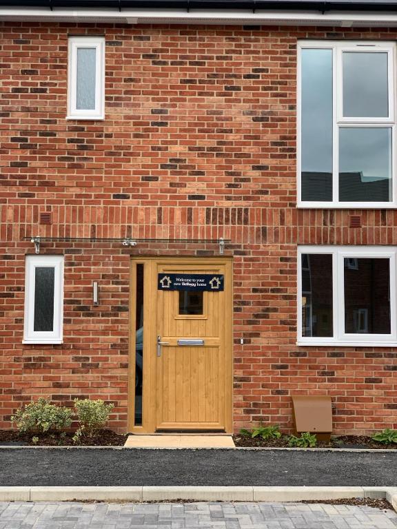 a brick building with a wooden door in front at LUXURY 3 BED HOME with MULTIPLE FREE PARKING BAYS Early Check-in Late Check- Out Allowed in West Thurrock