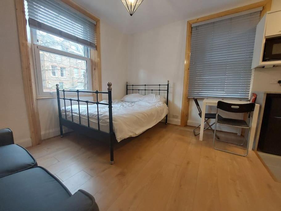 una camera con un letto e una sedia di Newly refurbished studio a Londra