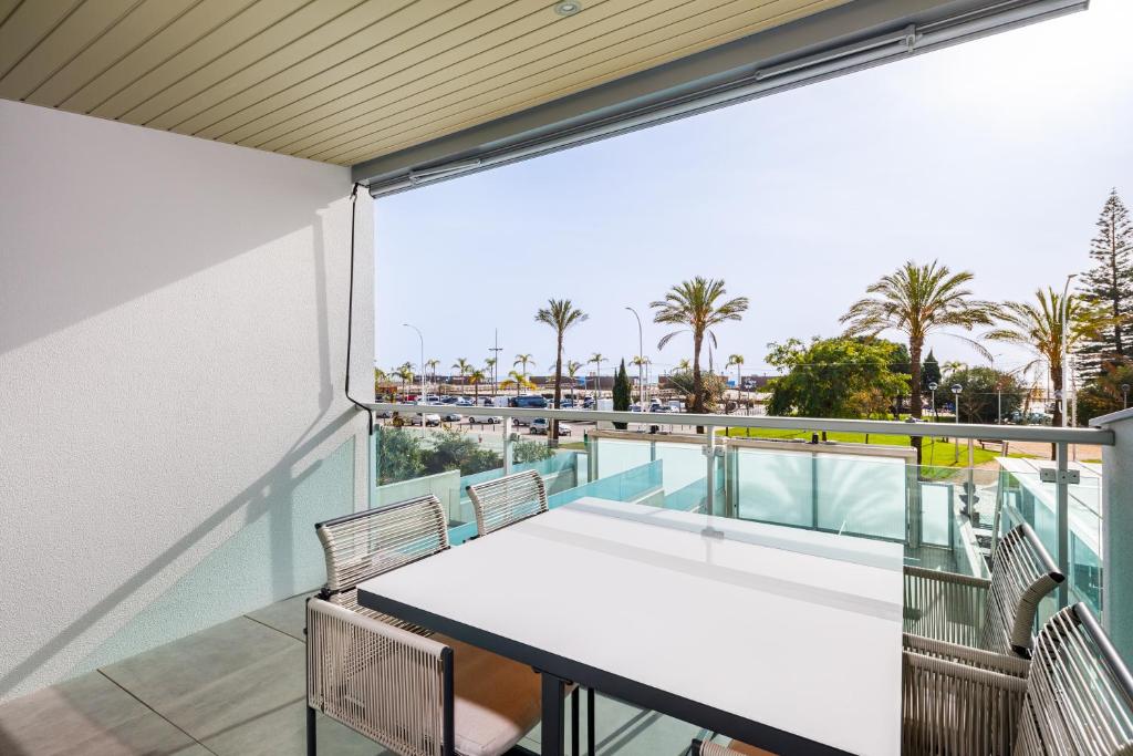 ein Balkon mit Tisch und Stühlen und Blick auf das Meer in der Unterkunft Kasino II 1º A in Monte Gordo