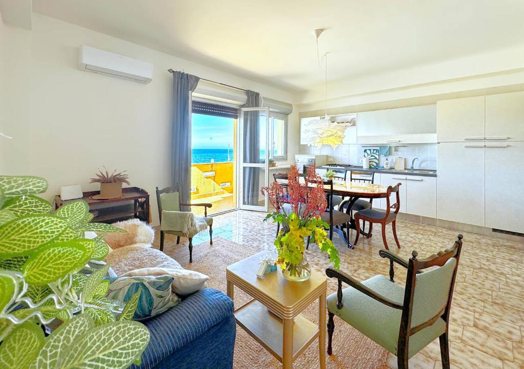 a living room with a couch and a dining room at Solemar Sicilia - Casa Bella in Bagheria