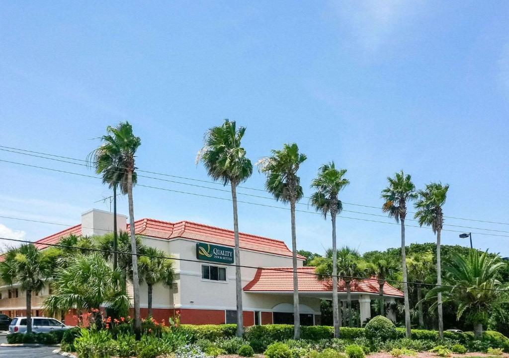 un hotel con palmeras delante en Quality Inn & Suites St Augustine Beach Area, en St. Augustine Beach