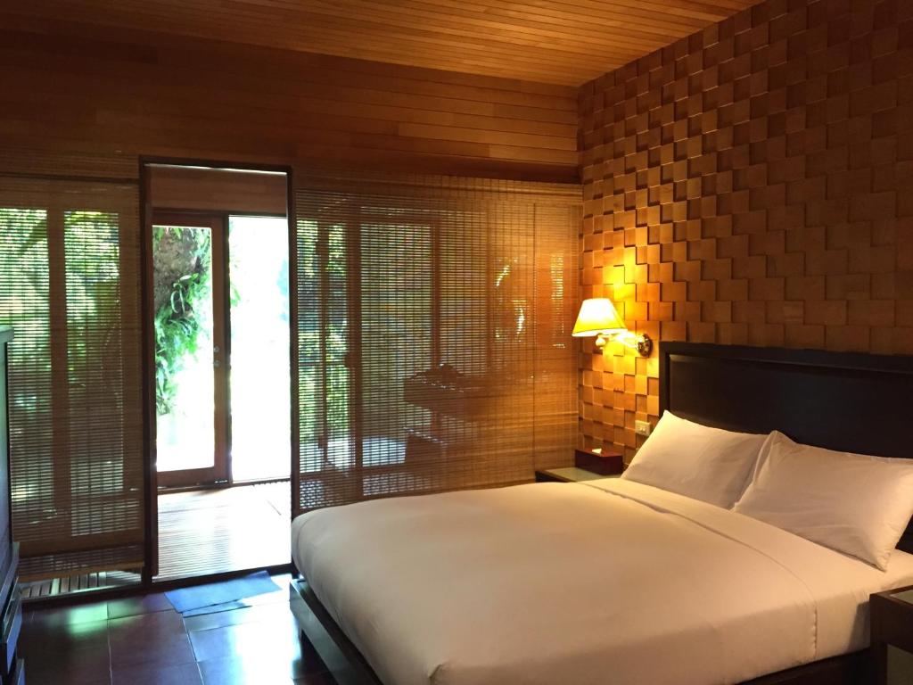 a bedroom with a large white bed and a brick wall at Silk Valley SPA Resort in Taipei
