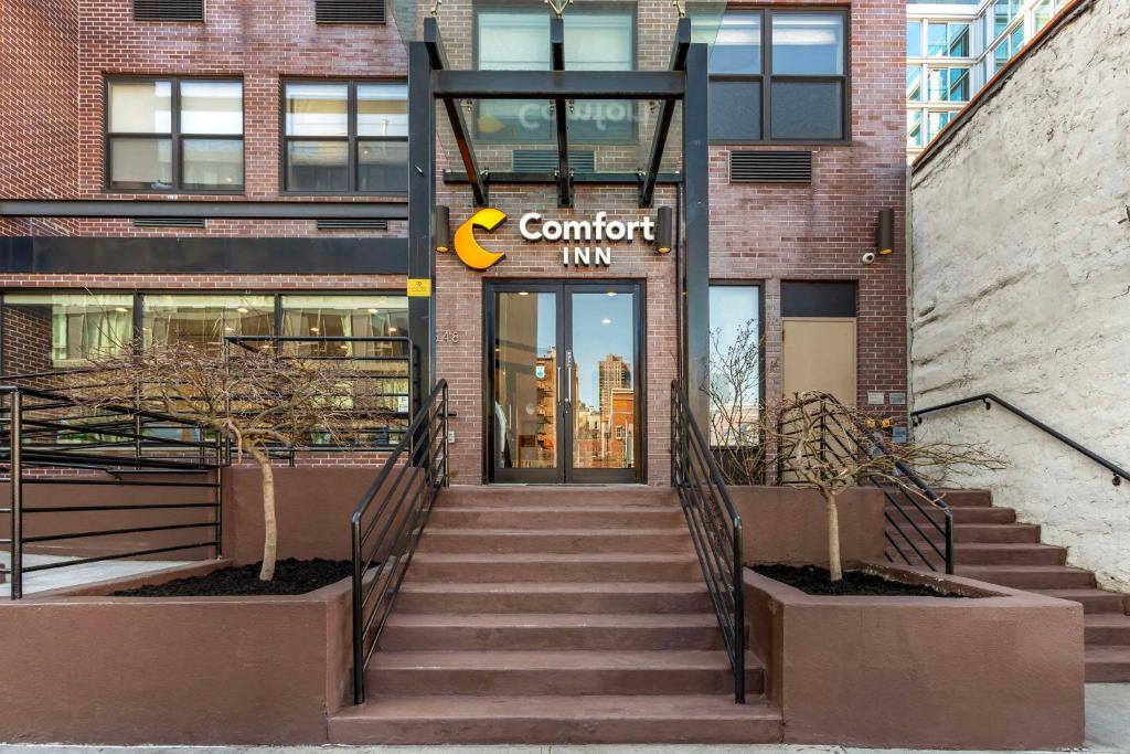 una entrada a un edificio con un cartel que lee posada confort en Comfort Inn Manhattan - Midtown West, en Nueva York