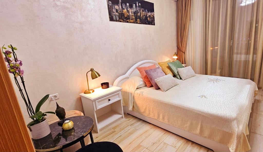 - une petite chambre avec un lit et une table dans l'établissement Iaki Apartment Mamaia, à Mamaia