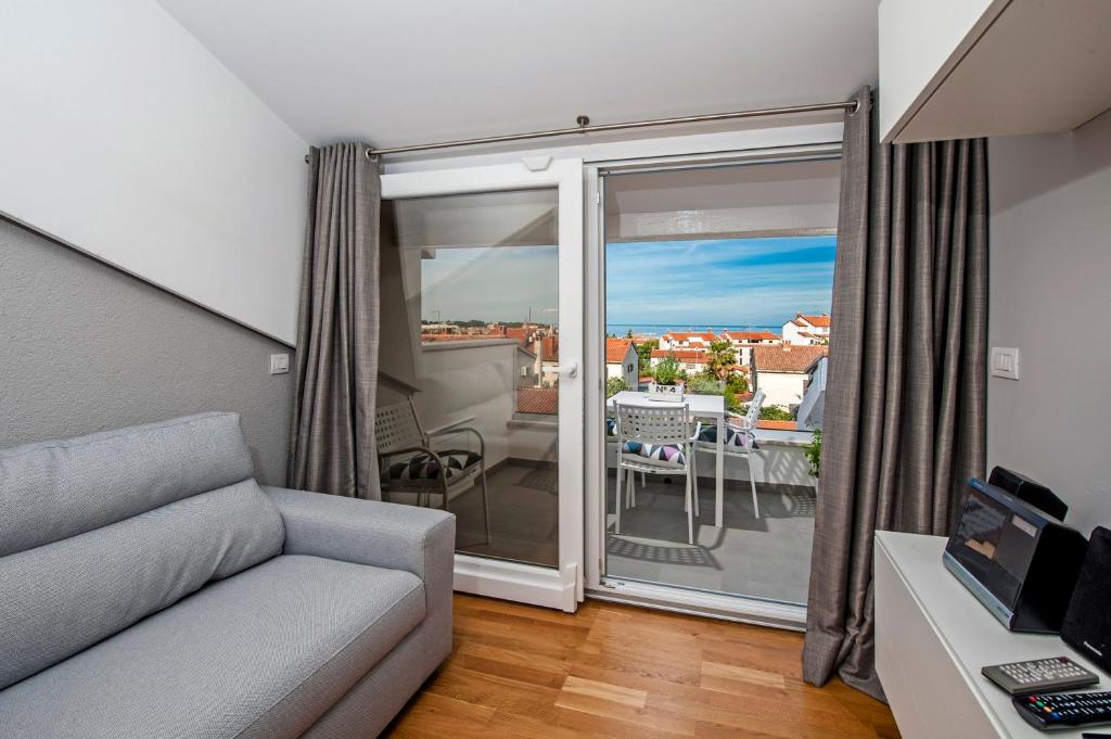 sala de estar con sofá y vistas a un balcón en Apartment Lili, en Poreč