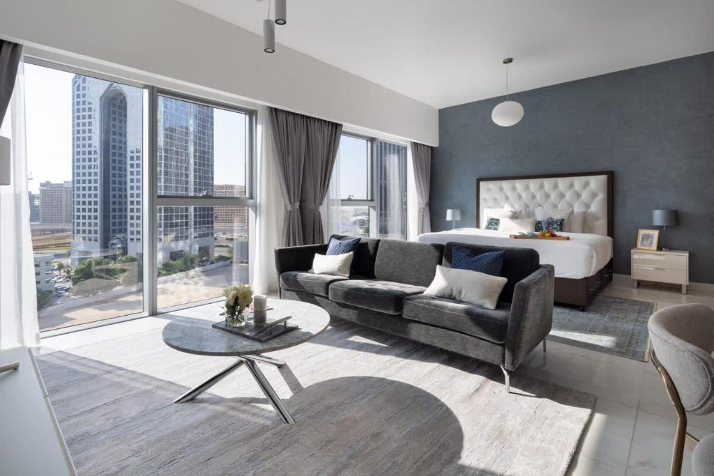 a living room with a bed and a couch and a table at Frank Porter - Central Park Towers in Dubai