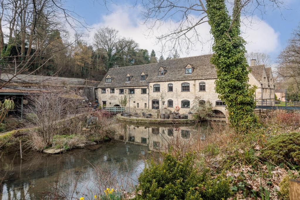 a large stone building next to a river at Egypt Mill Hotel and Restaurant in Nailsworth
