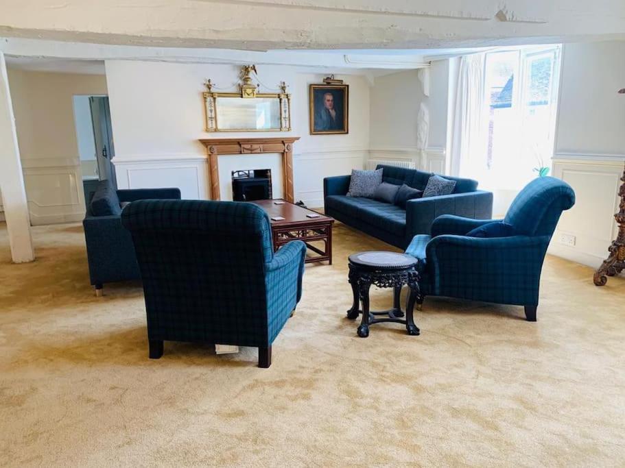 a living room with blue chairs and a table at 4 Bed 17th century Coach House in Brasted