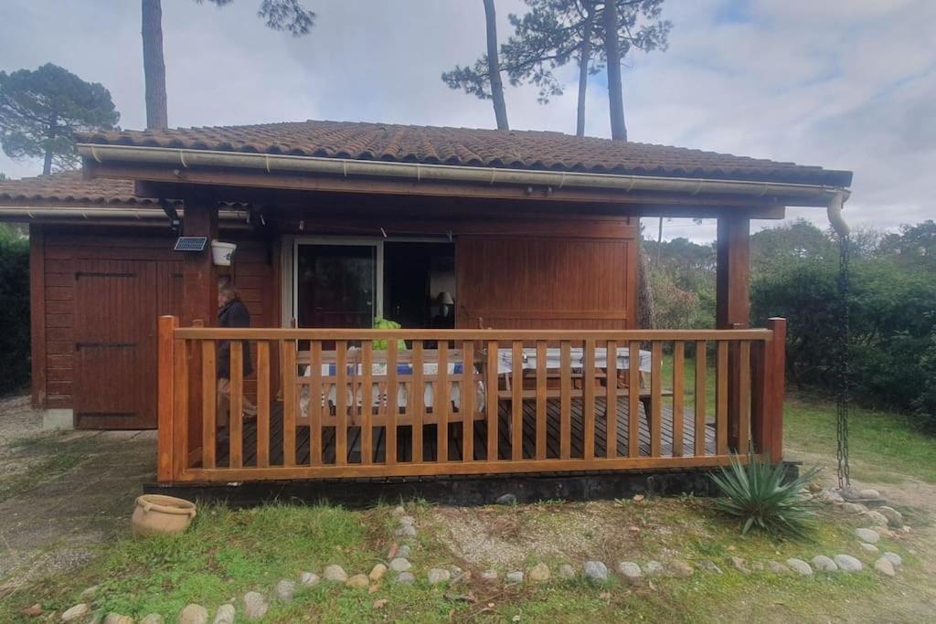 una pequeña casa con un gran porche de madera en Chalet dans un parc résidentiel de loisir - 0102, en Soulac-sur-Mer
