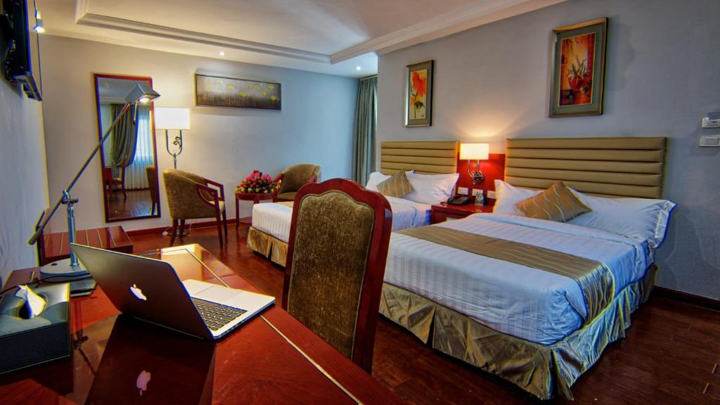 una habitación de hotel con 2 camas y un ordenador portátil en un escritorio en ZEMARIAS INTERNATIONAL HOTEL, en Mekʼelē