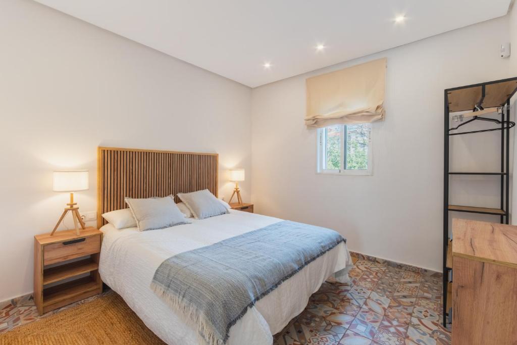 Un dormitorio con una cama grande y una ventana en Manolete apartamento, en Jerez de la Frontera