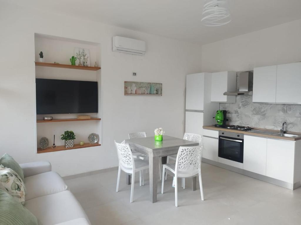 kuchnia i jadalnia ze stołem i krzesłami w obiekcie Costamia Casa Vacanze w mieście Santa Maria di Castellabate