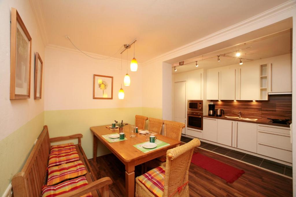 eine Küche und ein Esszimmer mit einem Holztisch und Stühlen in der Unterkunft Appartement Bakker in Kaprun