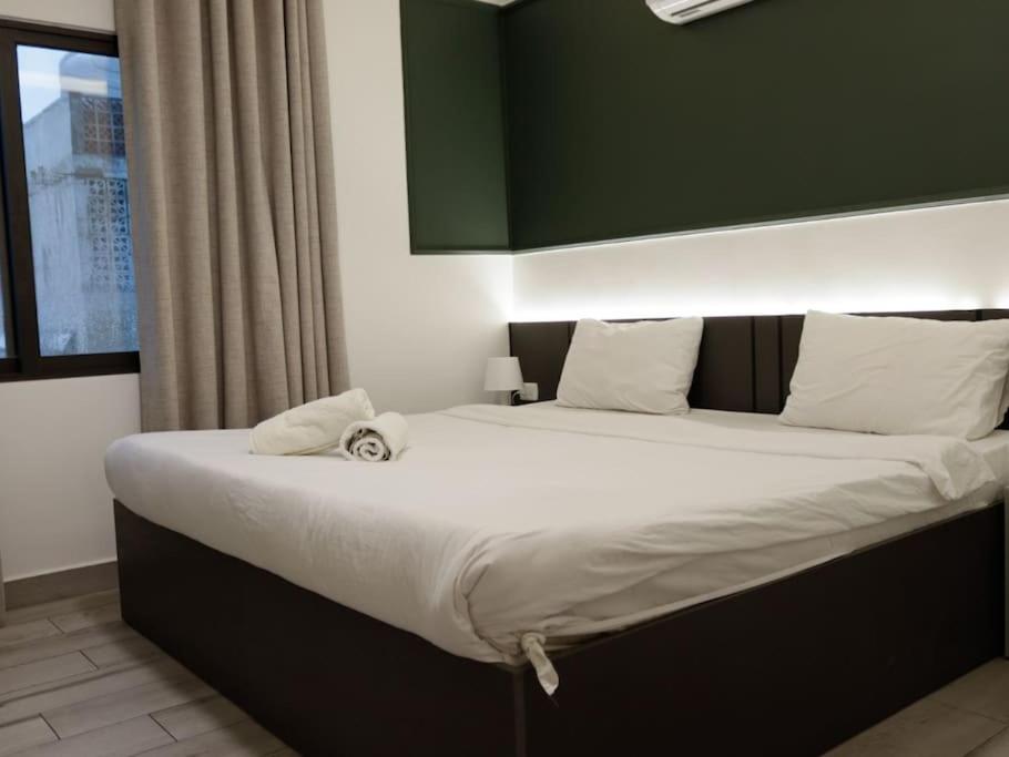 a large bed in a room with a green wall at privet (35)near downtown JRE in Amman