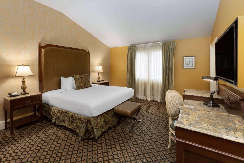 een hotelkamer met een bed en een televisie bij The Lafayette by LuxUrban in New Orleans