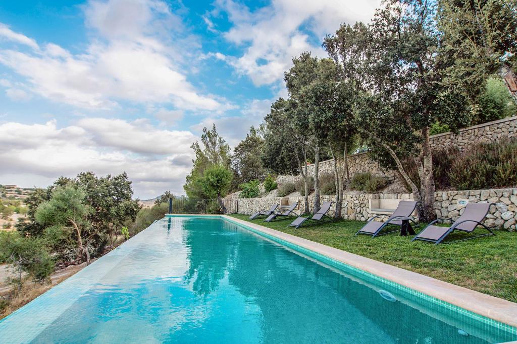 - une piscine avec des chaises longues à côté d'un mur dans l'établissement Lloret de vistalegre -3065 Mallorca, à Lloret de Vistalegre