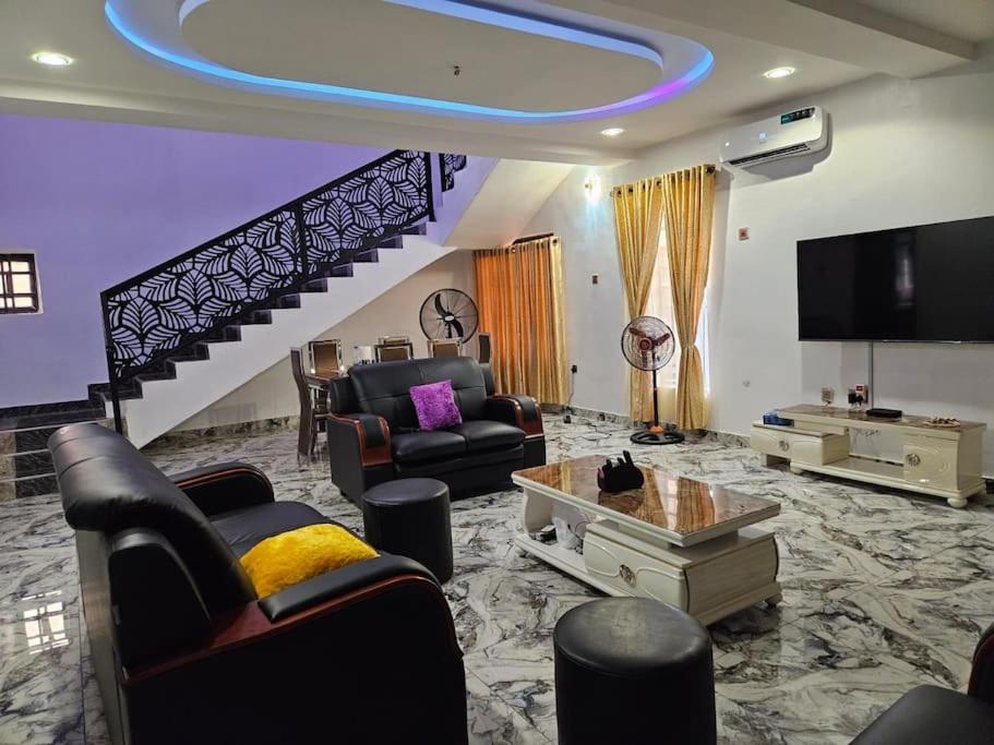 a living room with a couch and a tv at Glory Apartment in Ibadan