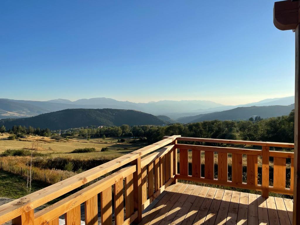 une terrasse en bois avec vue sur les montagnes dans l'établissement Chalet Mont-Reve, à Font-Romeu-Odeillo-Via