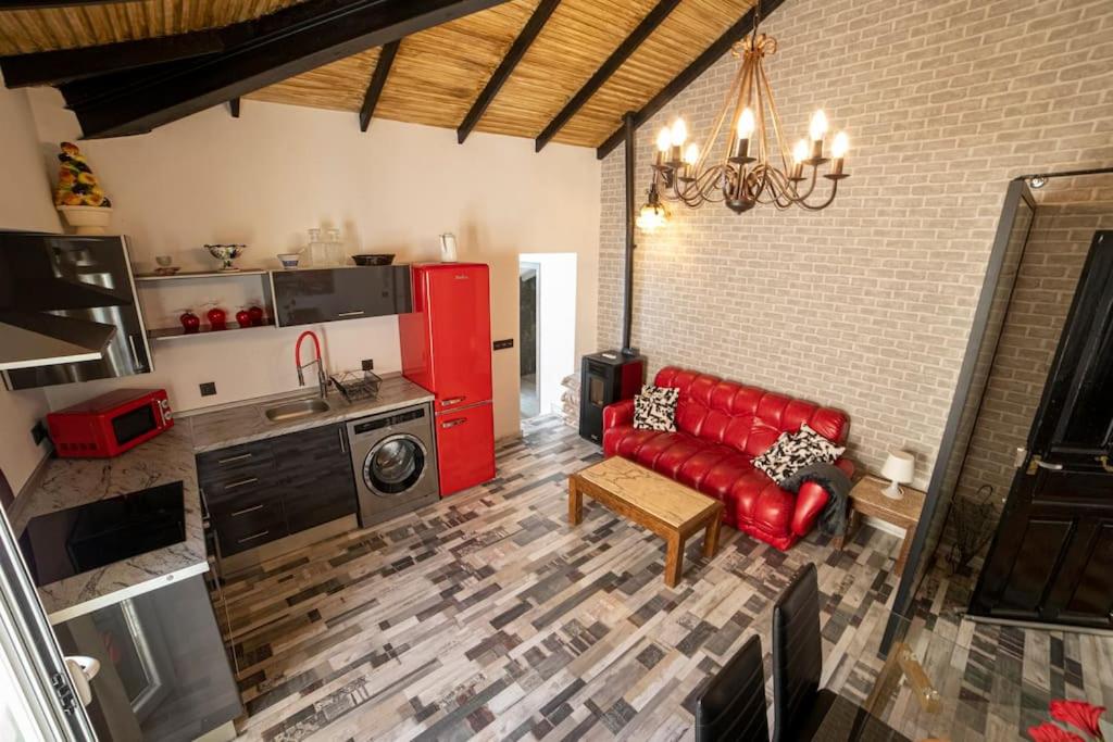 a living room with a red couch and a kitchen at Apartamento Rojo in Ateca