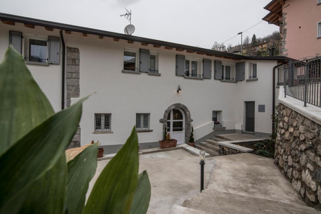 a courtyard of a house with a stone wall at Villa Mariolino in San Pellegrino Terme